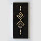 A vertical rectangular black wall art panel featuring a central abstract geometric design in metallic gold and silver tones, mounted against a plain light gray wall.