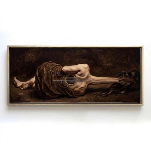 A framed horizontal canvas print of a surreal painting depicting a draped figure lying on the ground while holding a large acoustic guitar, shown against a plain white wall.